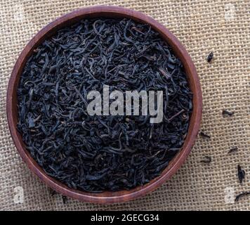 Getrocknete Assam-Teeblätter in einer Holzschüssel Stockfoto
