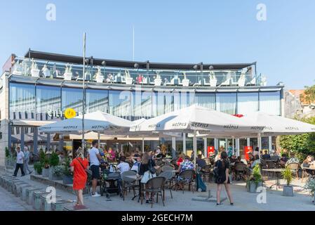 Die Restaurantterrasse ist wieder geöffnet. Auf der Außenterrasse können Gäste einen Kaffee oder ein Getränk genießen. Die Menschen genießen einen sonnigen Tag im Café im Freien.Liepaja, Lettland 13-08-2021 Stockfoto