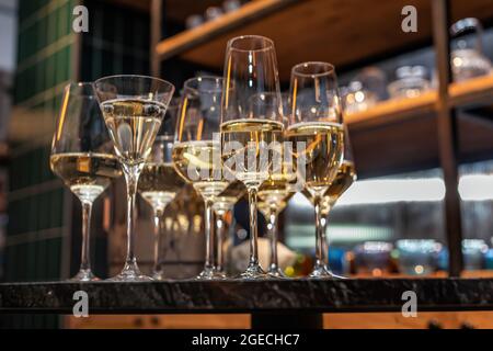 Viele verschiedene Weingläser auf dem Tisch. Stillleben von Gläsern mit alkoholischem Getränk auf der Vitrine. Stockfoto