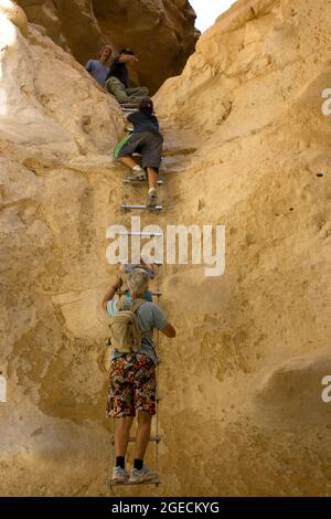 Wanderer klettert die Seilleiter in einer wassererodierten Höhle am Barak-Strom, Aravah-Wüste, Israel, Stockfoto
