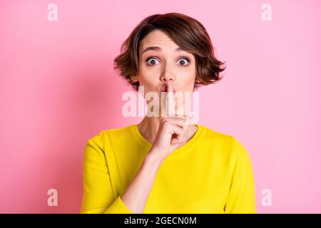 Portrait von attraktiven lustigen geheimnisvollen braune-haarige Mädchen zeigt shh Zeichen isoliert über rosa Pastellfarben Hintergrund Stockfoto