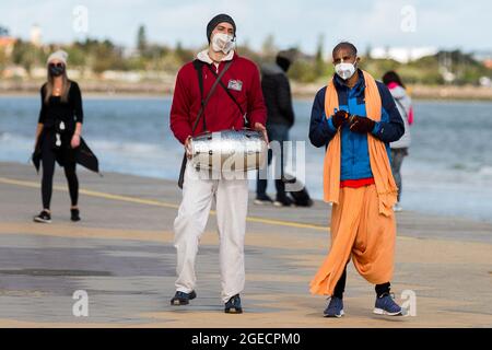 Melbourne, Australien, 9. August 2020. Hare Krishnas Gesang wird fröhlich auf dem St Kilda Foreshore während der COVID-19 in Melbourne, Australien, gesungen. Während die Beschränkungen der Stufe 4 die Stadt Greater Melbourne weiterhin erdrosseln, wurden über Nacht weitere 394 neue Coronavirus-Fälle aufgedeckt, zusammen mit den 17 Todesfällen, Victorias tödlichster seit Beginn der Krise. Kredit: Dave Hewison/Speed Media/Alamy Live Nachrichten Stockfoto