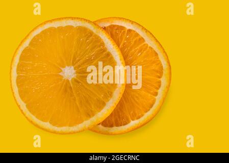 Zwei orangefarbene Scheiben auf gelbem Hintergrund mit Kopierraum isoliert Stockfoto