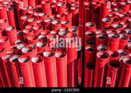 Kanalisationsrohre aus rotem Kunststoff. Das verwendete Material ist das thermoplastische Polymer Polyvinylchlorid (PVC). Einer der am häufigsten produzierten Kunststoffe Stockfoto