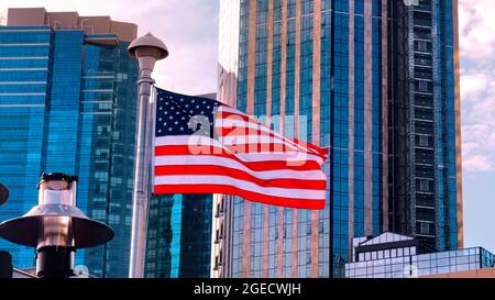 Fliegende amerikanische Flaggen, umgeben von Hochhäusern in New York Stockfoto