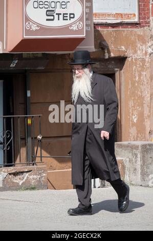 Ein älterer orthodoxer jüdischer Mann, wahrscheinlich ein Rabbi, geht auf der Lee Avenue in Williamsburg, Brooklyn, New York City. Stockfoto