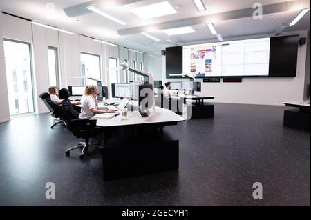 Offenbach, Deutschland. August 2021. Beamte arbeiten im zentralen Kontrollzentrum, wo Notrufe eintreffen, während eines Rundgangs durch das neue Polizeihauptquartier in Südosthessen. Quelle: Sebastian Gollnow/dpa/Alamy Live News Stockfoto