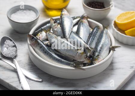 Frische Sardinen, Zitrone und Salz in der Küche, Nahaufnahme Stockfoto