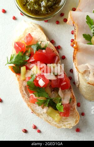 Köstliche Bruschetta-Snacks auf weißem strukturiertem Hintergrund Stockfoto