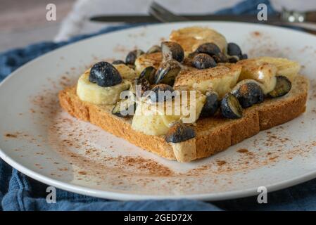 Bananen-Sandwich mit Blaubeeren, Nussbutter und Zimt Stockfoto