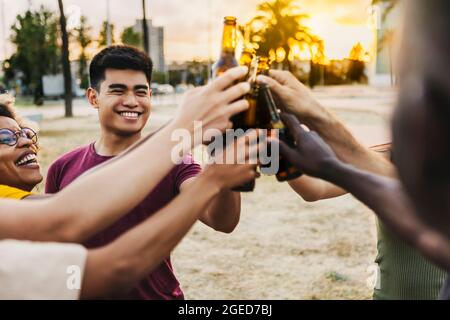 Multirassische Freunde feiern und toasten Bier auf der Strandparty Stockfoto