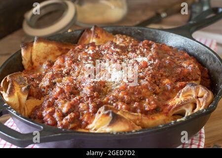 Italienische Küche. Gefüllte Pfannkuchen mit Mozzarella-Käse, garniert mit Bolognese-Sauce und Parmesankäse Stockfoto