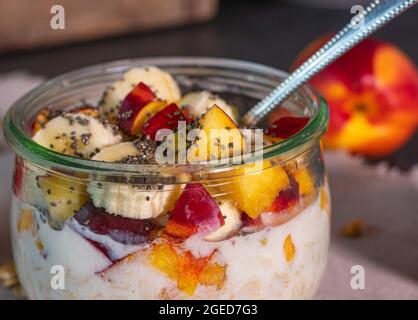 Hafer über Nacht mit Obst und Chiasamen in einer Glasschüssel auf dem Küchentisch Stockfoto