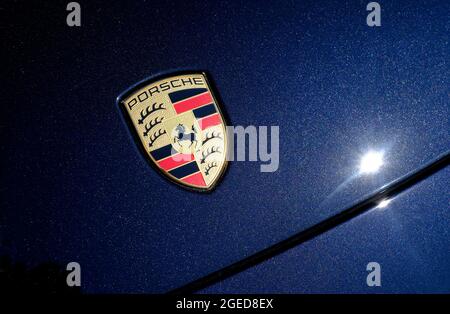 porsche Emblem Abzeichen auf blauer Motorhaube des macan Modells Stockfoto