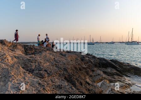 Formentera, Spanien: 2021. August 18: Menschen beobachten den Sonnenuntergang am Strand von Ses Illietes auf der Insel Formentera im Sommer 2021. Stockfoto