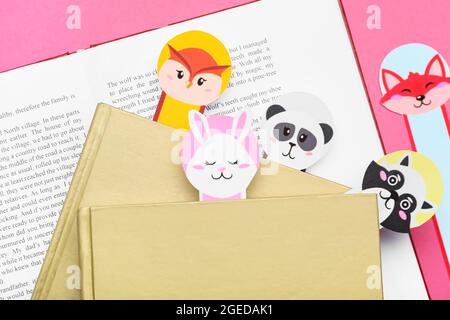 Niedliche Lesezeichen mit Büchern auf farbigem Hintergrund Stockfoto