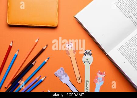 Niedliche Lesezeichen mit Büchern und Papeterie auf farbigem Hintergrund Stockfoto