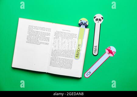Niedliche Lesezeichen mit Buch auf farbigem Hintergrund Stockfoto