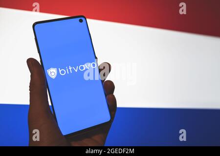 Bitvavo App-Logo auf dem Smartphone in der Hand mit den Niederlanden verschwommen Flagge Hintergrund. Europäische Plattform für Kryptowährungen. Stockfoto