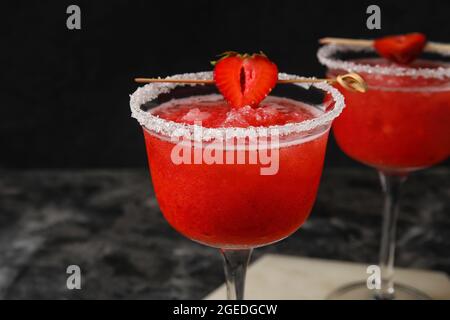 Gläser von leckeren Erdbeer margarita auf dunklem Hintergrund Stockfoto