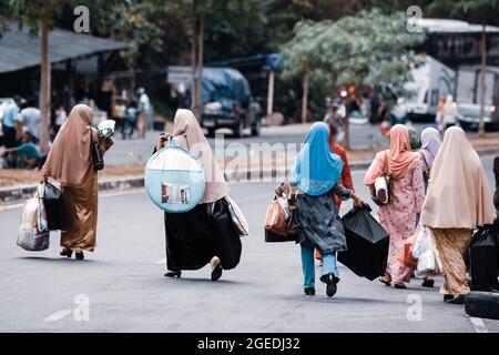 Rückansicht einer Gruppe von Touristen, die Geräte auf dem zollfreien Markt in der Nähe der Grenze zwischen Thailand und Malaysia kaufen. Satun, Südthailand. Stockfoto