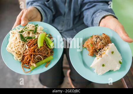 Authentisches Thai-chinesisch-malaiisches Street Food. Chinesische gebratene Eiernudeln, serviert mit Desserts, süßen klebrigen und thailändisch-chinesischen Pudding. Betong, Thailand. Stockfoto