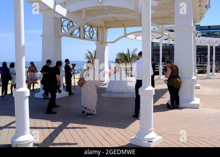 Das frisch verheiratete Paar posiert unter einem Baldachin auf dem Boardwalk in Long Branch, New Jersey Stockfoto