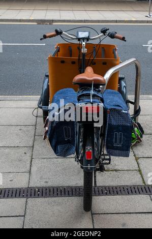 Ein Elektrofahrrad mit Babboe-Kurve, das in einem Fahrradbereich außerhalb von Marken und Spencers auf der grassierenden Horse Street Norwich geparkt ist Stockfoto