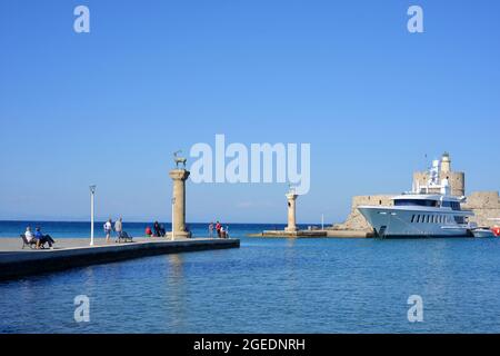 Rhodos-Stadt, Skulpturen am Eingang des Mandraki-Hafens, Yachten, Boote und die Festung St. Nicolas Stockfoto