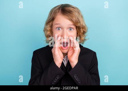 Foto von lustigen kleinen blonden Jungen Schrei tragen Uniform isoliert auf blauem Hintergrund Stockfoto