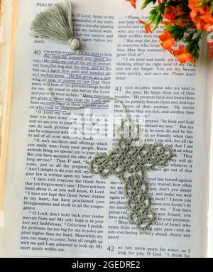 Handgehäkelte Lesezeichen liegen in der Bibel. Seite wird geöffnet, um tröstende Worte der Ermutigung. Herbstblumen schmücken die Ecke. Stockfoto