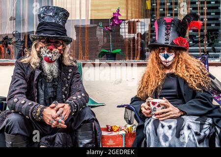 Ein Paar in Dampf-Punk- oder Gothic-Kleidung genießt eine Tasse Tee. Stockfoto