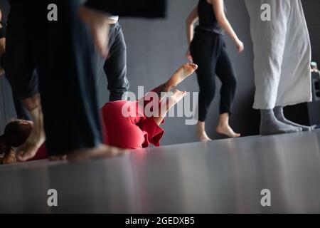 Mehrere Tänzer bewegen sich auf dem Boden und in der Kontaktimprovisation absichtlich mit Bewegungsunschärfe und Unschärfe-Bokeh Stockfoto