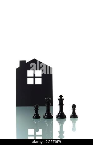 Konzeptuelle Fotografie von zwei Schachfiguren, die ein schwarzes heterosexuelles Paar darstellen, das eine Familie mit zwei Kindern bildet; mit der Silhouette Stockfoto