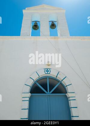 Glockenturm zwei Glocken kleine weiß getünchte Kapelle Tür mit Bogen Kimolos Insel Kykladen Griechenland. Unter Ansicht der traditionellen orthodoxen Kirche blauer Himmel Hintergrund Stockfoto