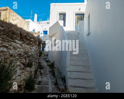 Weißgetünchte Gebäude und Treppen leeres Kopfsteinpflaster schmale Gasse sonnigen Tag, Kythnos Insel, Ziel für Sommerurlaub Griechenland. Traditionelles Griechisch A Stockfoto