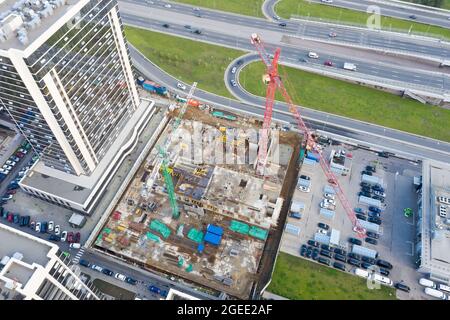 Luftaufnahme Großbau einer Wohnanlage mit Blick auf Baukräne und Straße am Stadtrand Stockfoto