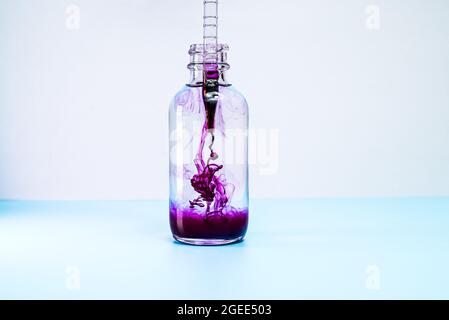 Glasflasche mit violetter Farbe auf weißem Hintergrund Stockfoto