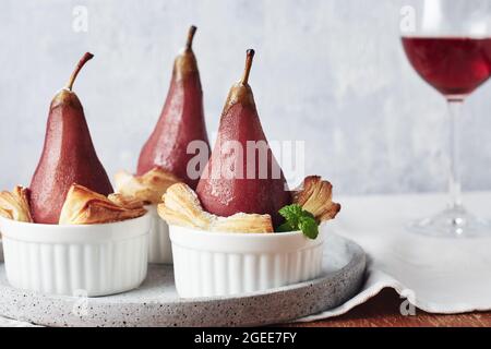 Pochierte Birnen in Rotwein mit Zimt. Stockfoto