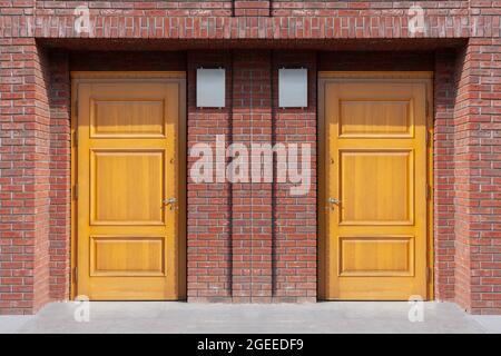Zwei Holztüren, Eingang zum Haus, roter Ziegel. Stockfoto