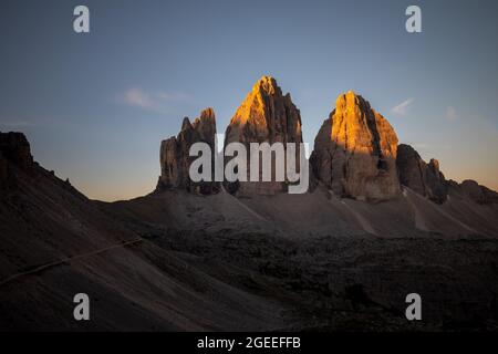 Drei Gipfel des Lavaredo (drei Zinnen oder Tre Cime di Lavaredo) im Nationalpark Sextener Dolomiten bei Sonnenaufgang mit Licht auf den Gipfeln Stockfoto