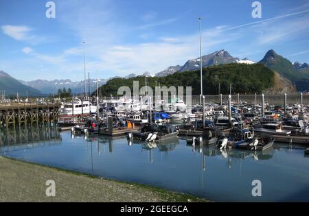 Boote in allen Formen und Größen. Fischerboote, Charter- und Vergnügungsboote schweben auf dem stillen Wasser des kleinen Bootshafens von Valdez. Tolles Chugach Mo Stockfoto