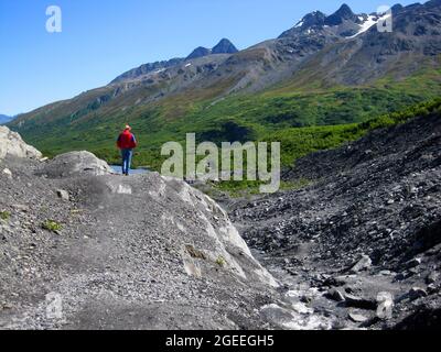 Mann wandert um den Worthington Glacier in Alaska. Der Glacier Lake liegt am Fuße der Klippe. Aussichtsplattform für Gletscher ist in der Ferne zu sehen. Stockfoto