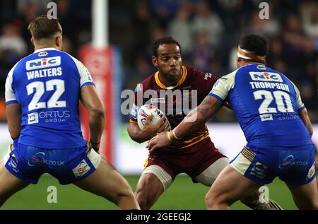 Leroy Cudjoe von Huddersfield Giants (Mitte) wurde von Bodene Thompson von Leeds Rhinos (rechts) während des Matches der Betfred Super League im Emerald Headingley Stadium in Leeds angegangen. Bilddatum: Donnerstag, 19. August 2021. Stockfoto