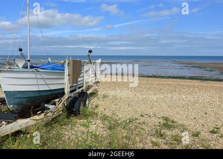 Ein kleines Boot auf dem Kiesstrand von Tankerton mit Blick auf die Nordsee Stockfoto