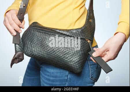 Geschlossene schwarze Ledertasche auf casual Frau Taille isoliert Stockfoto