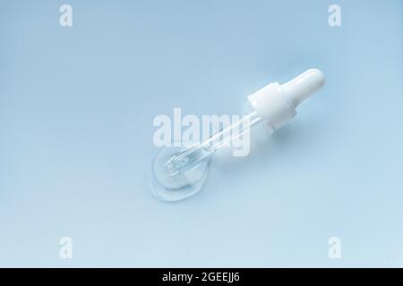 Mit flüssiger Hyaluronsäure pipettieren. Kosmetikkonzept. Hellgrauer Hintergrund. Draufsicht, Nahaufnahme. Stockfoto