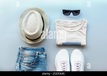 Frauen Sommer Mode flach Lay mit schönen stilvollen Casual Kleidung und Accessoires auf grauem Hintergrund. Draufsicht Stockfoto