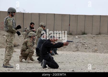 Uniformierte afghanische Polizisten, die in der Stadt Khost stationiert sind, feuern M9 Beretta-Pistolen auf einen Kleinwaffenbereich im Lager Parsa, Provinz Khowst, Afghanistan, 30. Januar 2013. Soldaten der US-Armee, die dem Team 28 der Sicherheitskräfte, der Task Force 3/101, zugewiesen wurden, planten die Reichweite und unterstützten die AUP beim sicheren Üben mit ihren Waffen. (USA Armeefoto von Sgt. Kimberly Trumbull / Veröffentlicht) Stockfoto