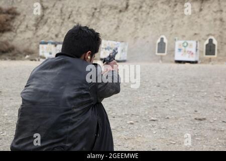 Ein Mann des afghanischen Nationalen Sicherheitsdirektorats feuert eine M9-Beretta-Pistole auf einen Kleinwaffenbereich in Camp Parsa, Provinz Khowst, Afghanistan, 30. Januar 2013. Soldaten der US-Armee, die dem Team 28 der Sicherheitskräfte, der Task Force 3/101, zugewiesen wurden, planten die Reichweite und unterstützten die uniformierte afghanische Polizei und die NDS beim sicheren Üben mit ihren Waffen. (USA Armeefoto von Sgt. Kimberly Trumbull / Veröffentlicht) Stockfoto